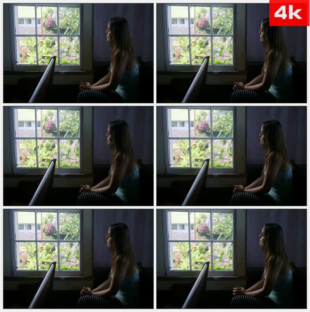 4K0291美女坐在暗暗的房间里向窗外眺望 高清实拍视频素材